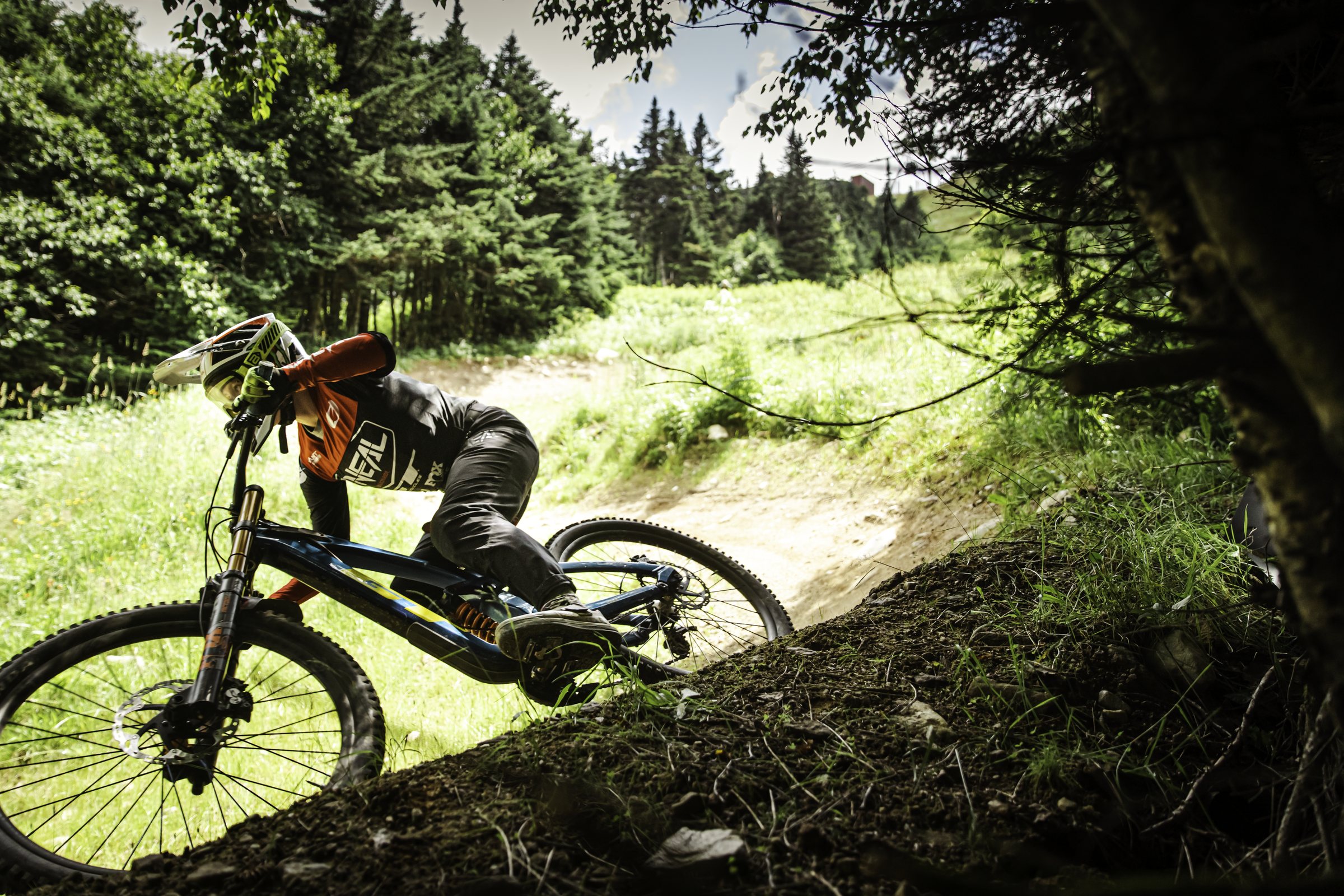 Killington bike park — a rider railing a bermed dirt corner in summer