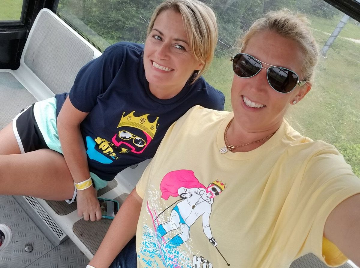 Two fans in King of Spring shirts riding the chairlift