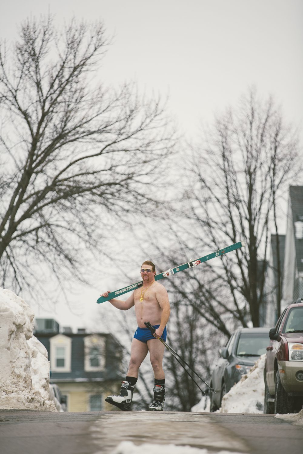 The King on a Vermont street, skis over his shoulder